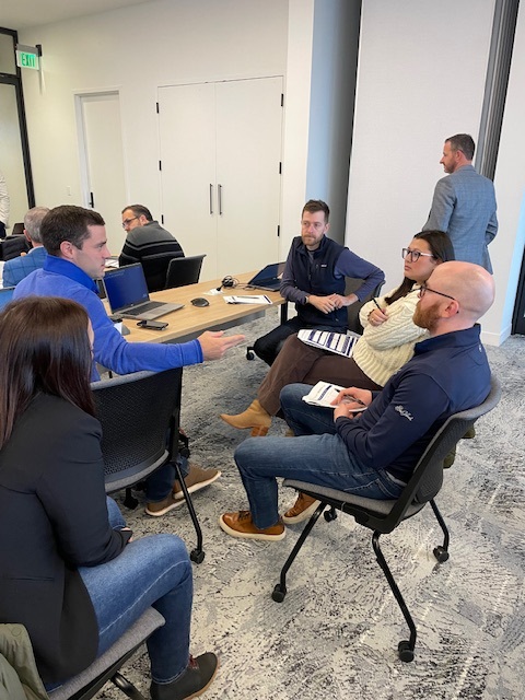 A Clustr trainer coaching a small breakout group in conversation