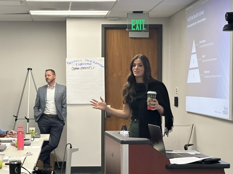 Clustr trainer leading a business development session at the podium