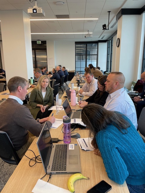 Participants collaborating on laptops during a hands-on Clustr working session
